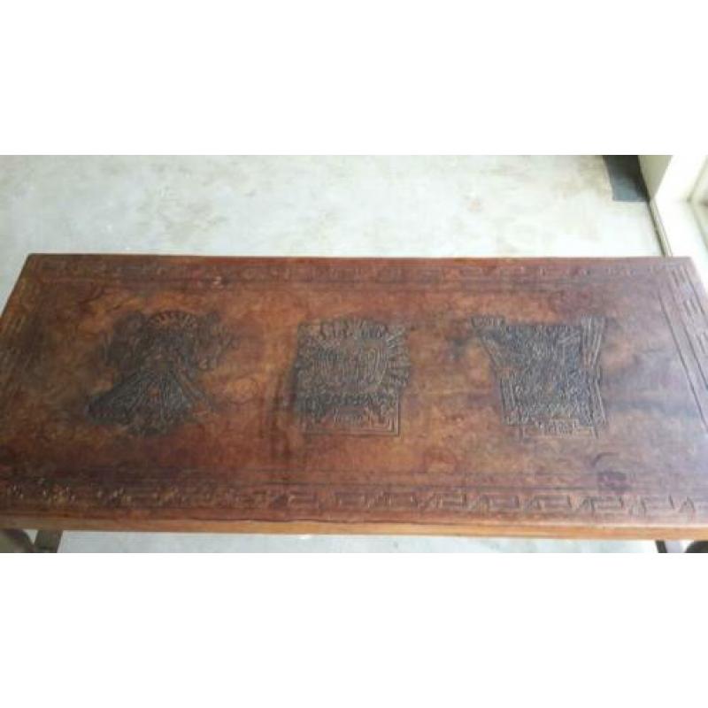 Lage tafel van hout met een leren bovenkant met figuren